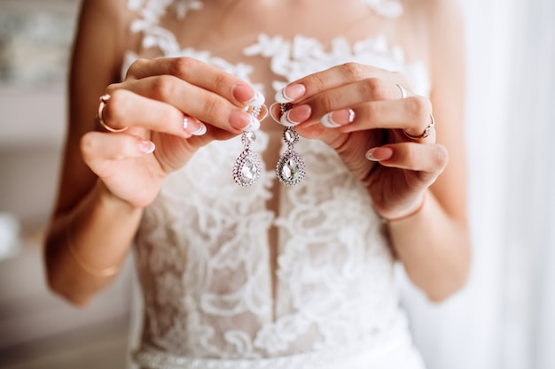 Belles boucles d'oreilles sur la paume de la mariée