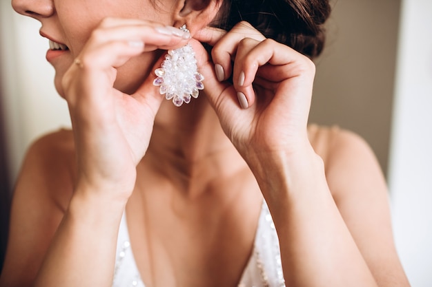 Belles boucles d'oreilles sur la paume de la mariée