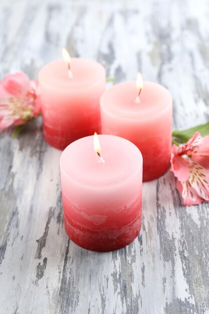 Belles bougies avec des fleurs sur fond de bois