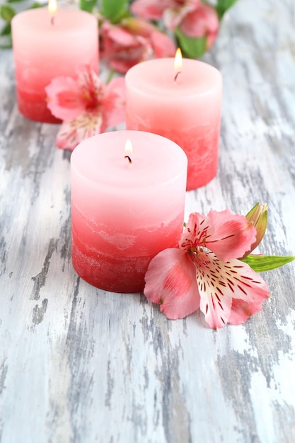 Belles bougies avec des fleurs sur fond de bois