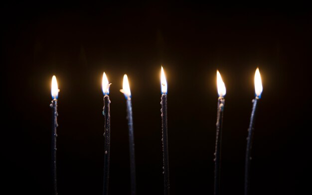 Belles bougies qui brûlent dans le noir