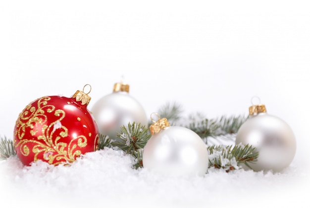 Belles boules blanches et rouges de Noël avec branche de sapin et neige sur fond blanc