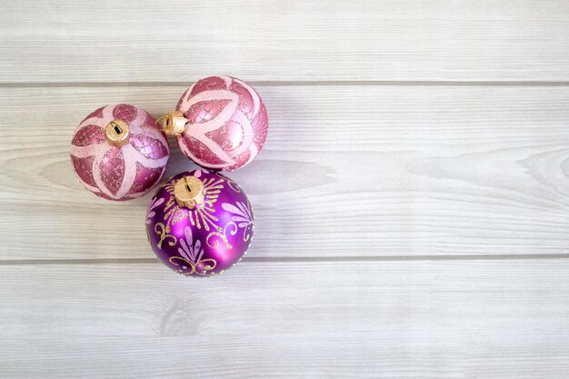 Belles boules de Noël lilas avec des motifs sur un fond en bois clair se bouchent