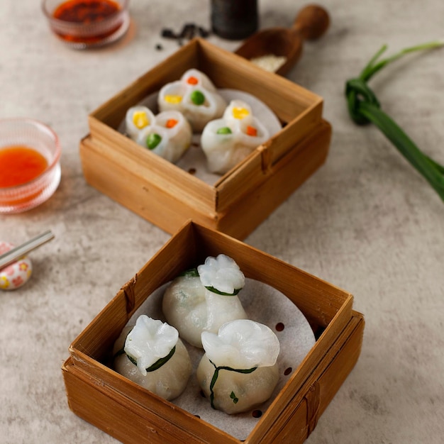 Belles boulettes de ciboulette cuites à la vapeur de style hongkongais sur la table en ciment rustique. Appelé Gu Chai en thau et en chinois appelé Jiu Cai Jiao, apéritif chinois thaïlandais