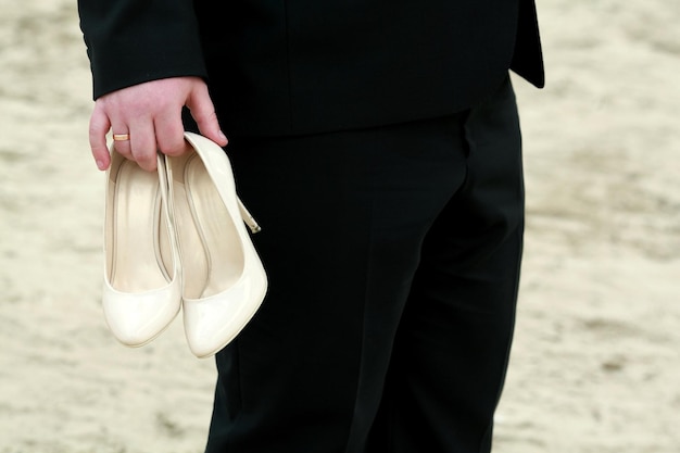 Belles chaussures de mariage dans les mains du fiancé