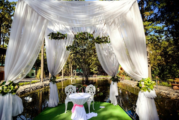 Belles décorations de mariage pour la cérémonie dehors par temps ensoleillé