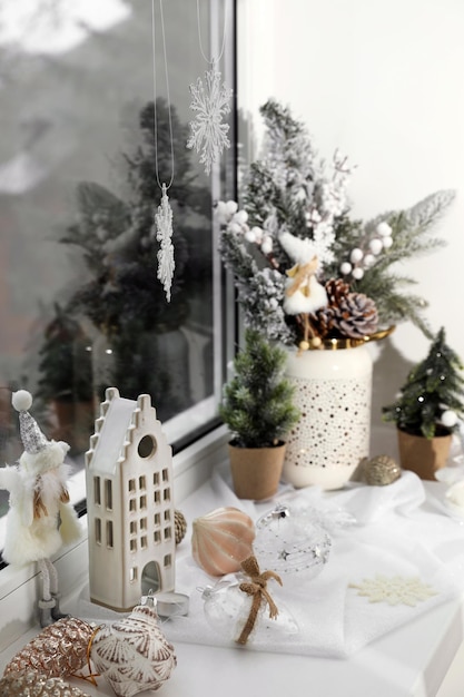 Photo de belles décorations de noël et de petits sapins sur le seuil de la fenêtre à l'intérieur