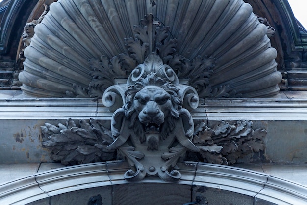 Belles décorations en pierre au dessus de la porte d'entrée avec la tête de lion