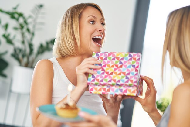 Belles deux filles adultes dans la maison avec un gâteau d'anniversaire