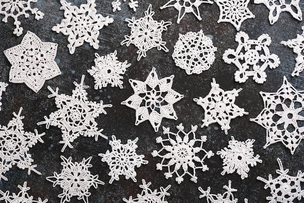 Photo belles étoiles et flocons de neige au crochet en coton blanc variés sur fond sombre