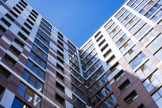 Belles façades d'immeubles de grande hauteur contre le ciel bleu par une journée ensoleillée