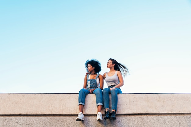 Belles femmes assises dans la rue. Concept de la jeunesse.