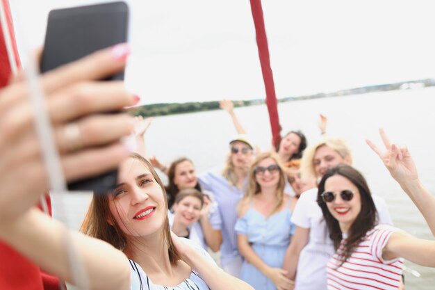 De belles femmes mûres se tiennent sur le yacht et prennent des selfies entre copines se reposant en été sur un