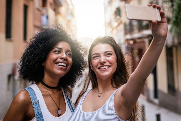 Belles femmes prenant un autoportrait dans la rue. Concept de la jeunesse.