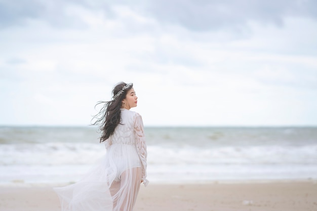 Belles femmes en robe blanche se promenant joyeusement à la plage