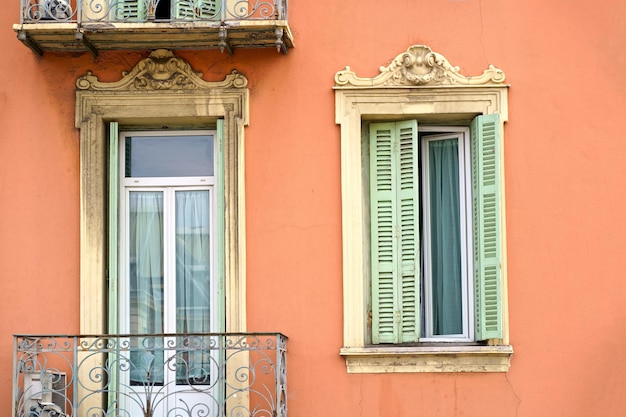 Belles fenêtres françaises Cadres de fenêtres avec volets en bois Fenêtres d'une maison privée avec pots de fleurs et volets en bois