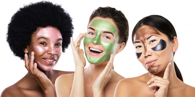 Photo belles filles multiethniques avec des masques peel-off colorés sur leurs visages