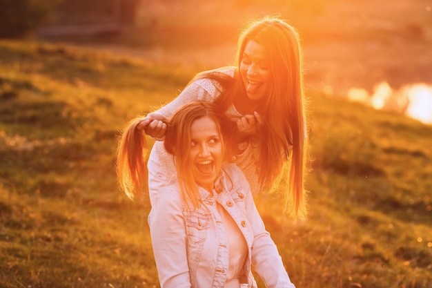 De belles filles ont décidé de s'amuser dans la nature et de montrer des grimaces amusantes le soir