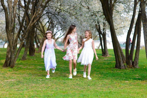 Belles filles en robes rétro marchant dans un jardin fleuri