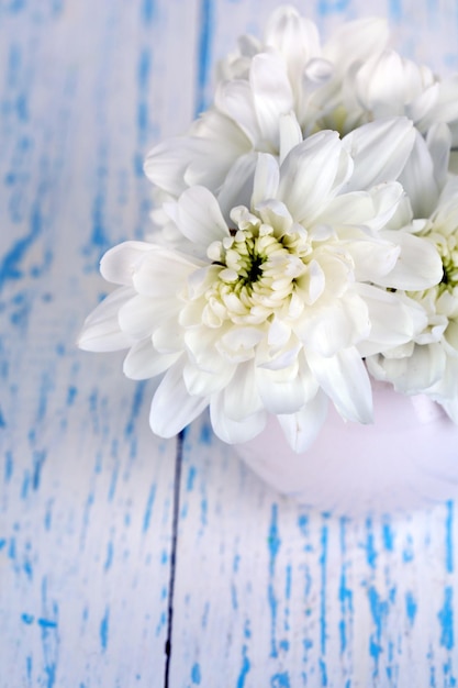 Belles fleurs de chrysanthème dans un vase sur une table en bois libre