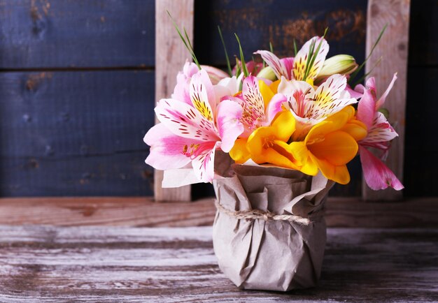 Belles fleurs dans un vase sur fond de bois