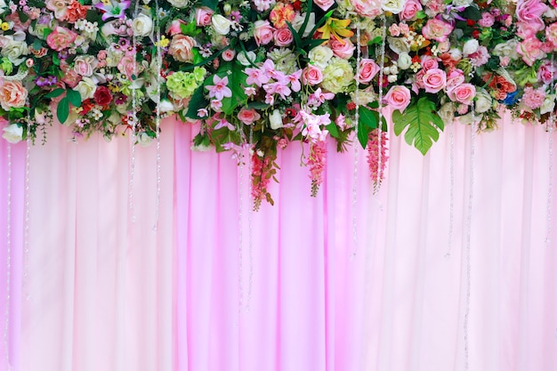 Belles fleurs fleurissent sur fond de rideau rose pour la scène de mariage