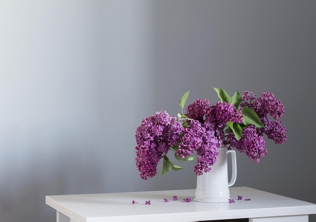 Belles fleurs lilas en pot blanc sur table en bois blanc