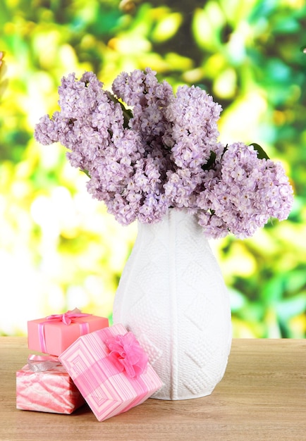 Belles fleurs lilas sur table sur fond clair