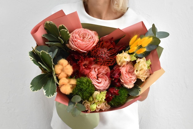 Belles fleurs pour les vacances Femme avec de belles fleurs dans les mains à l'intérieur fond bouquet de fleurs pour fleuriste