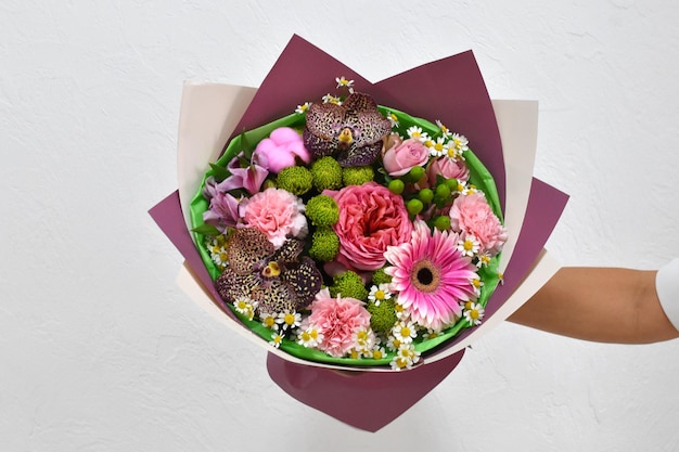 Belles fleurs pour les vacances Femme avec de belles fleurs dans les mains à l'intérieur fond bouquet de fleurs pour fleuriste