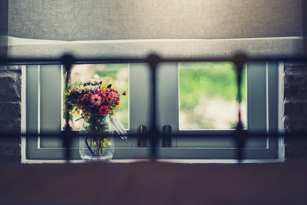 Photo belles fleurs près de la fenêtre