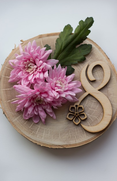 Belles fleurs roses sur une tranche de bois avec le numéro huit pour le 8 mars, Journée internationale de la femme