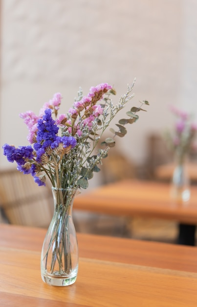 Belles fleurs séchées dans un vase en verre sur une table en bois, intérieur du restaurant