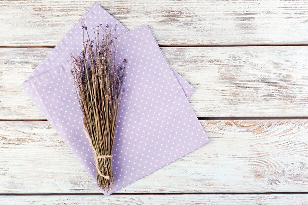 Belles fleurs sèches sur une serviette sur fond de bois