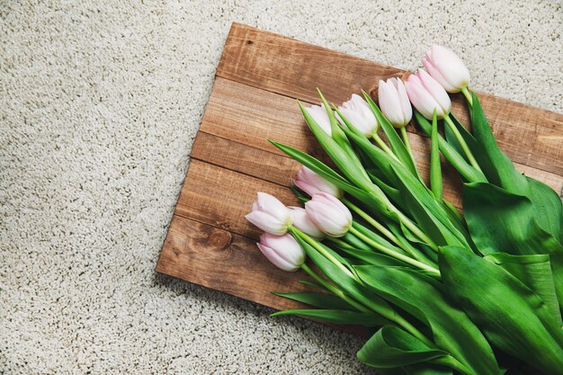 Belles fleurs de tulipes roses sur la planche de bois