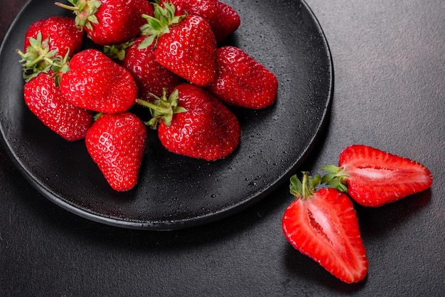 Belles fraises fraîches juteuses sur la surface en béton de la table