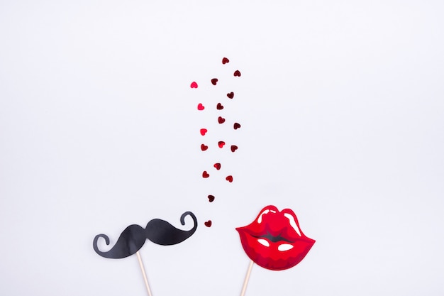 Belles garnitures avec une moustache d'homme et des lèvres de femme sur fond gris avec coeurs. Le concept des relations hétérosexuelles, Saint Valentin