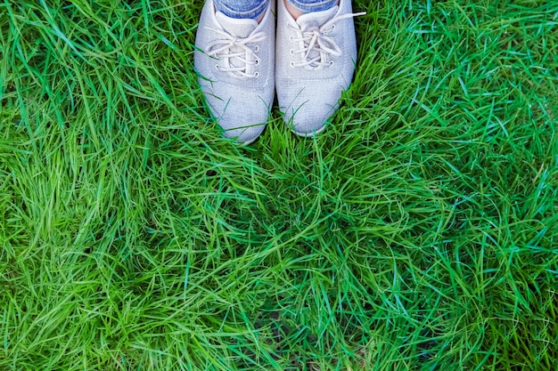 Belles jambes sur l'herbe en parc sur la nature