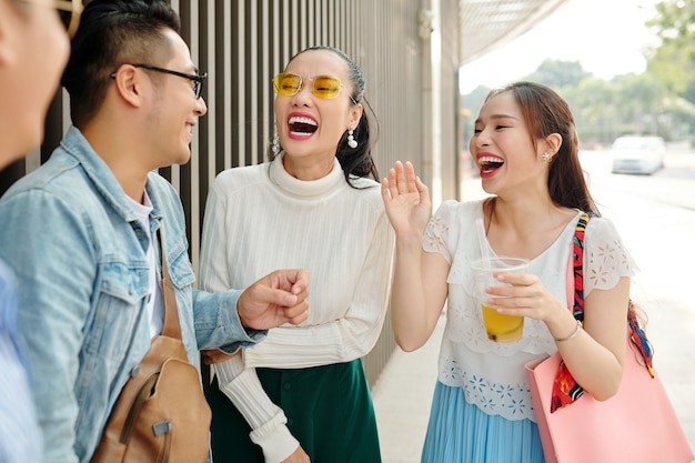 Belles jeunes femmes asiatiques riant des blagues de leur ami