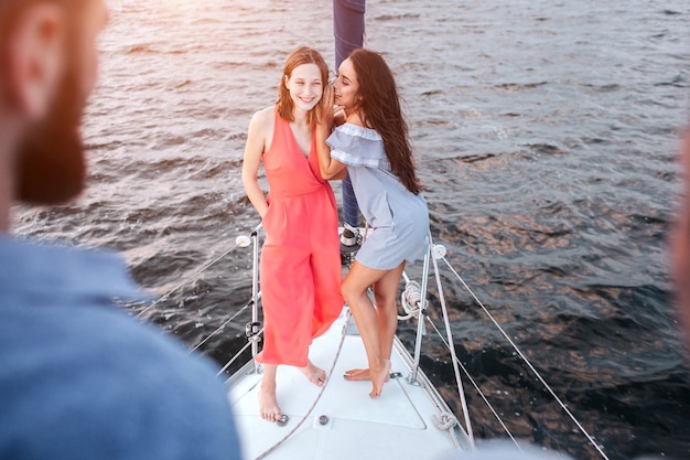 Belles jeunes femmes se tiennent ensemble et posent