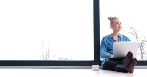 belles jeunes femmes utilisant un ordinateur portable sur le sol de sa maison de luxe