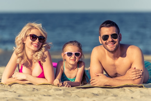 Belles jeunes parents et leur fille sur la plage.