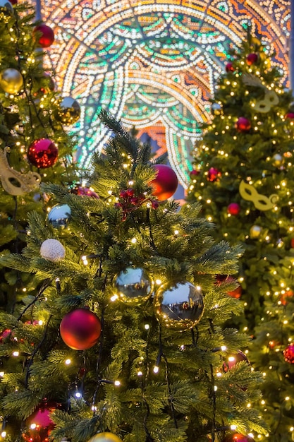 Belles lumières de Noël floues sur des sapins décorés le soir