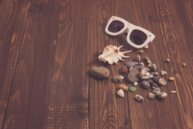 De belles lunettes de soleil et différents coquillages sont sur la table