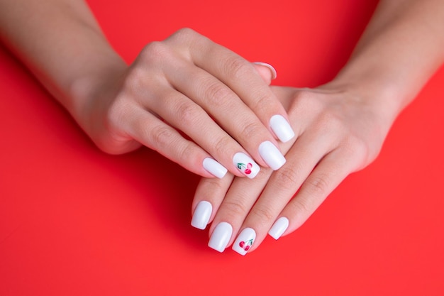 Belles mains féminines avec des ongles de manucure blancs