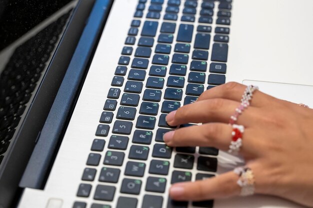 De belles mains féminines tapent sur un ordinateur portableTravail à distance sur ordinateur