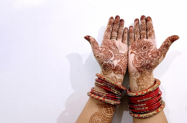 De belles mains de femmes indiennes avec un tatouage de henné isolé sur le blanc