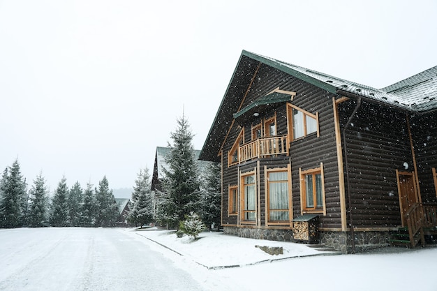 Belles maisons en bois dans les chutes de neige dans les montagnes