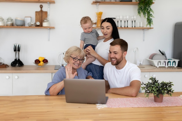 Photo belles personnes ayant un appel vidéo avec leur famille à la maison