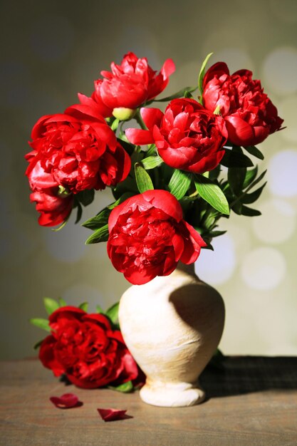 Belles pivoines roses dans un vase sur fond clair